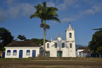 photo d'une église sur laquelle se projette l'ombre d'un cocotier
