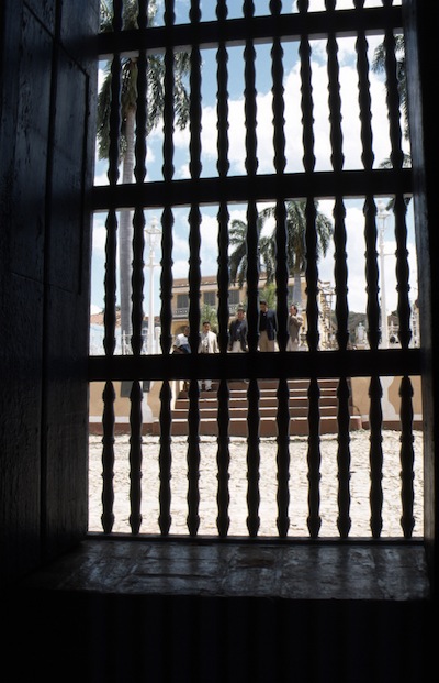 photo d'un groupe de personnes à travers des barreaux de porte 
