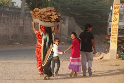 photo de femmes transportant des bouses de vaches séchées