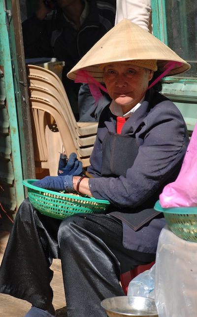 photo une famille d'une vendeuse coiffée du chapeau typique du Vietnam